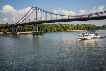 Tour of Kiev in the center of Europe. View of the Dnieper, Trukhanov island and a foot bridge. Park fountain and sunset on the horizon..