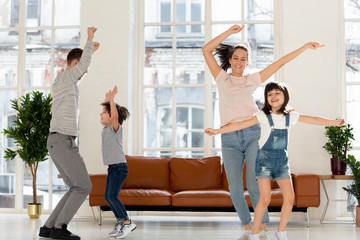 Joyful family enjoying dancing party in living room.
