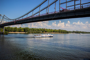 Tour of Kiev in the center of Europe. View of the Dnieper, Trukhanov island and a foot bridge. Park fountain and sunset on the horizon..