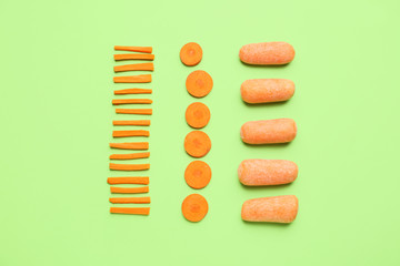 Fresh carrots with pieces on color background