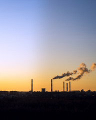 Colorful Magic Sunset. Dark smoke coming from the thermal power plant pipe. vertical photo