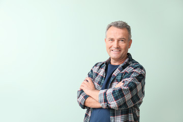 Portrait of stylish mature man on color background