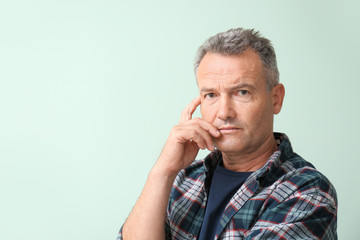 Portrait of stylish mature man on color background