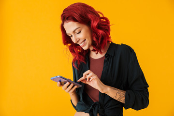 Image of attractive cheerful woman smiling and typing on cellphone