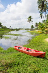 Small plastic canoe by a river at the Hippie Village in Arembepe - Bahia, Brazil