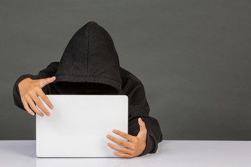 The hacker is sitting on his notebook's page and has a gray background.