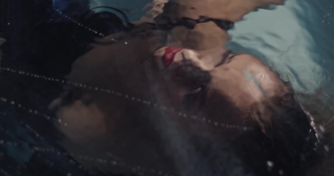 Top view on a woman underwater, pretty face with makeup and lipstick, 4k