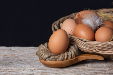 Eggs laying together on a wooden floor with a black background.