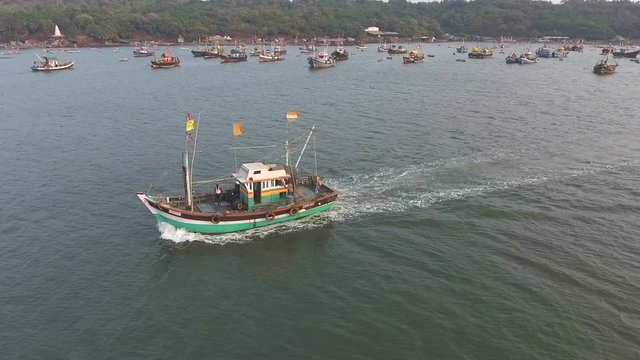 drone pan shot of fishing boat in a small port 
