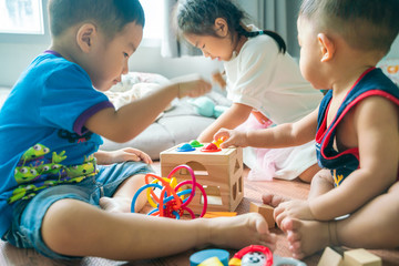 Group of baby playing in cozy room with toy