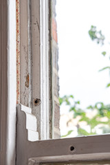 Shallow focus, isolated image of an old style sash window shown in the closed position. Part of the sash running cord can be seen on the left, within a wooden grove.