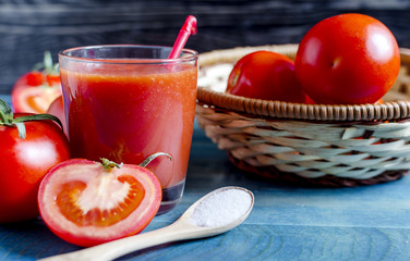 Tomato juice in a clear glass tomatoes in the background sharpness in the foreground
