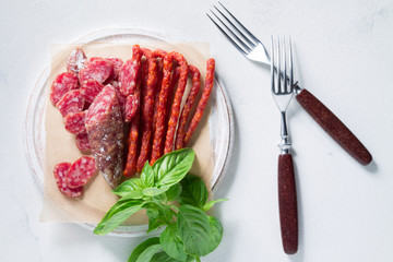 Set of chorizo sausages with a sprig of basil. Antipasti snack