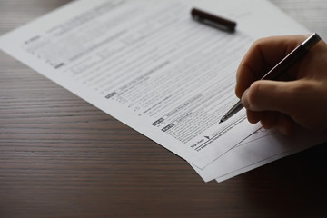 Obraz premium Business meeting. A man signs a contract. Male hand with pen makes notes in the office.
