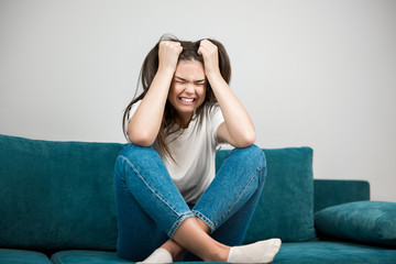 Fototapeta premium beautiful young woman crying feeling very depressed sitting on the sofa