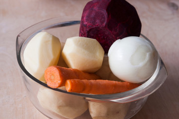 Raw vegetables for beet soup borsch. beet, carrot, potato, onion on glass dish