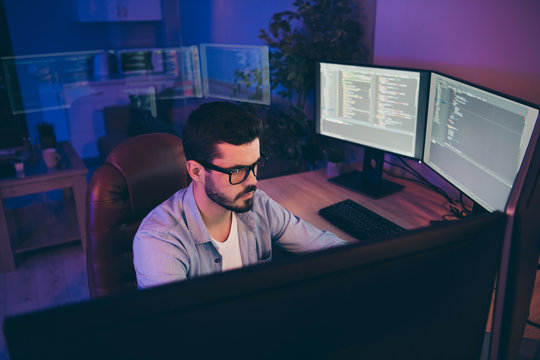 Photo of it specialist guy sitting comfy chair looking many monitors testing website algorithms serious content development expert dark night office indoors