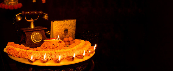 Diwali glowing Diya , flowers, Sweets and Gifts arranged in circular shape forming a design with copy space, selective focus , Indian festival , Extra copy space for text