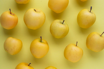 Yellow apples on a yellow background close-up.