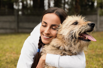 Female volunteer with homeless dog at animal shelter outdoors