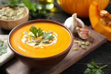 Delicious pumpkin soup in bowl on wooden table - Powered by Adobe