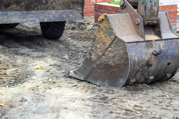 Macro shot of an excavator bucket on the ground / earthmoving machinery