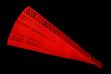 Red fan with a pattern closeup. Isolate on black background
