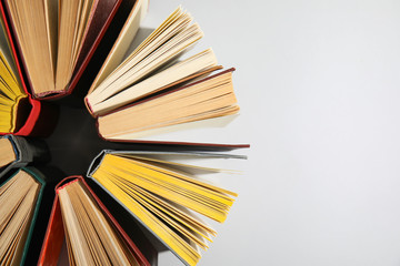 Circle made of hardcover books on grey background, flat lay