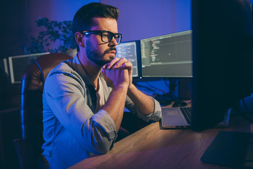 Profile photo of it-specialist guy working late at night sitting office chair looking monitors...