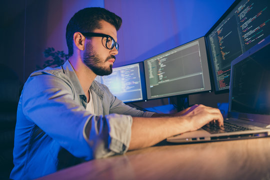 Profile side view portrait of his he nice attractive focused skilled guy writing cyber attack hack web network hardware software protection trouble shooting in dark room workplace station