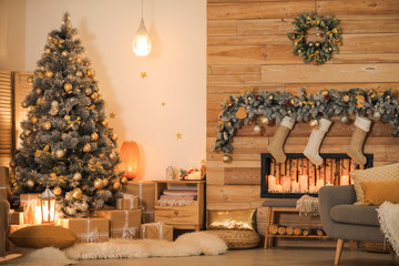 Stylish room interior with beautiful Christmas tree and decorative fireplace