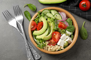 Delicious avocado salad with quinoa on grey table, flat lay