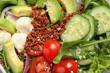 Delicious avocado salad with quinoa as background, closeup