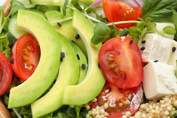Delicious avocado salad with quinoa as background, closeup