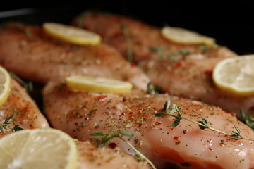 Chicken breasts with lemon and rosemary on baking sheet, closeup