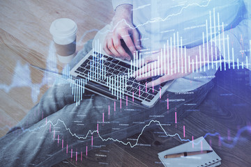 Forex graph with businessman working on computer in office on background. Concept of analysis. Double exposure.