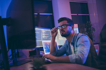 Profile photo of it specialist looking monitors testing website debugging system attentive...