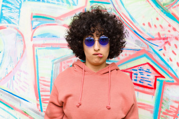 young pretty afro woman feeling clueless, confused and uncertain about which option to pick, trying...