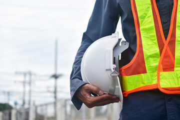 Close up hand holding white hard hat safety Engineer Technician Against Sky background