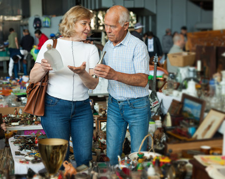 Mature man and his wife are visiting market of old things