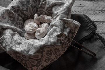 Fototapeta premium heap of meringues in a basket with a napkin in retro style