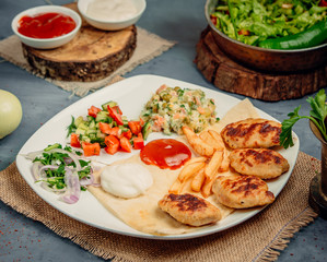 fried chicken cotletes with french fries and vegetables