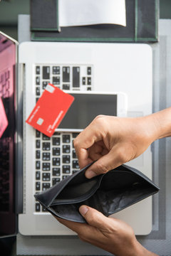 Man's hands holding an empty wallet with credit card