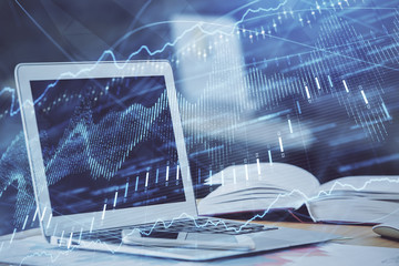 Forex graph hologram on table with computer background. Double exposure. Concept of financial markets.