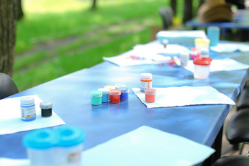 Gouache paints on blue table in park.