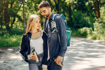 Tourists in a summer forest. Couple with a map.