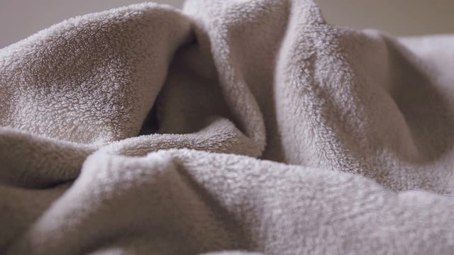 Close up, panning and shallow depth of field of of beige bathrobe texture