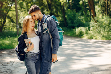 Tourists in a summer forest. Couple with a map.