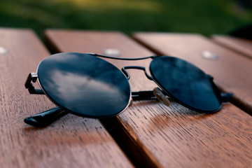 Fototapeta na wymiar sun glasses on a wooden background,