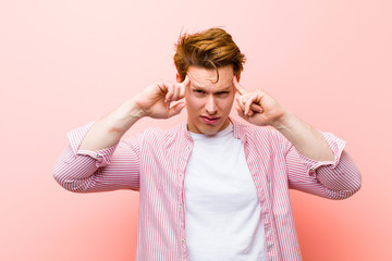 young red head man with a serious and concentrated look, brainstorming and thinking about a...